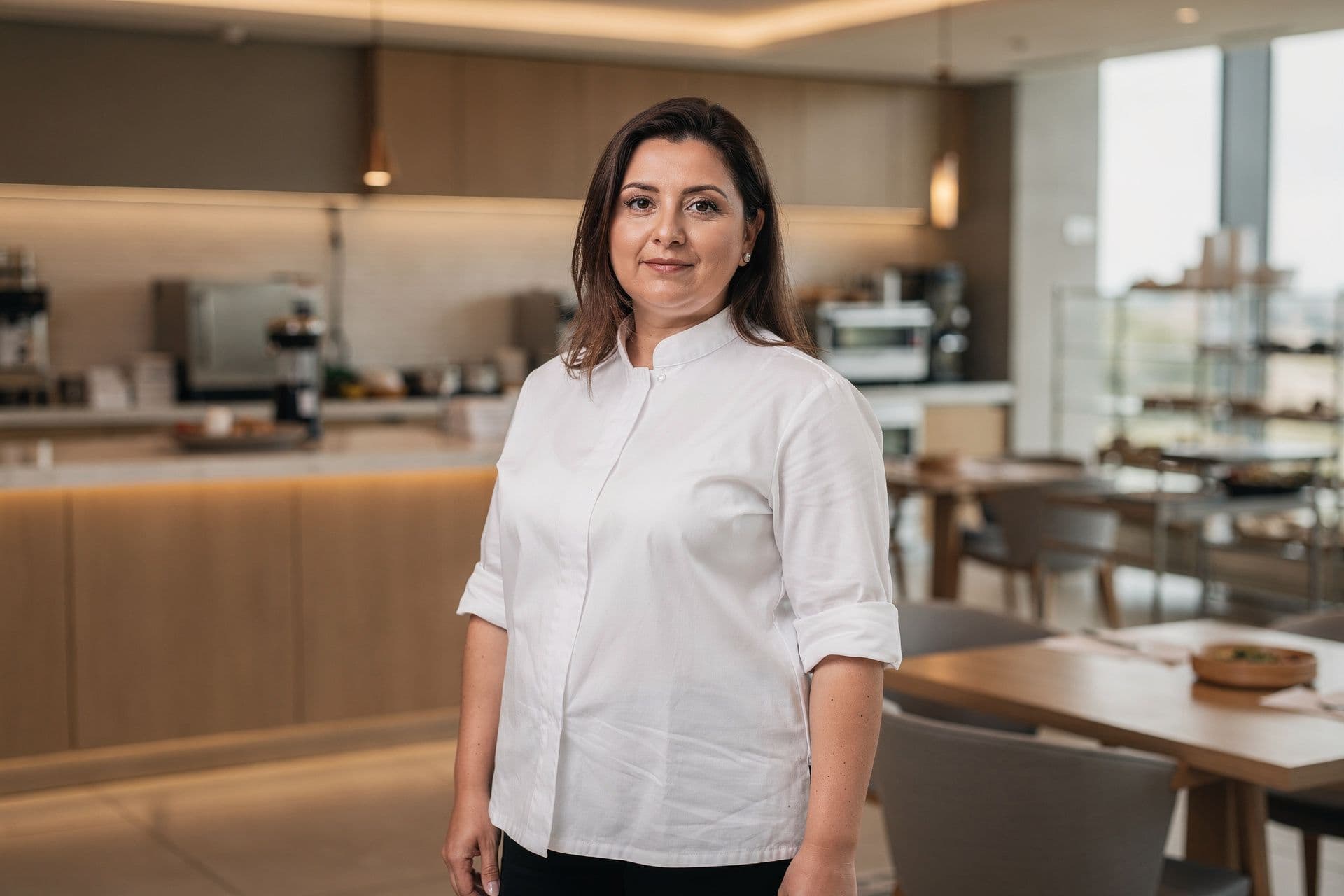 Katrina Ikonomopoulos, General Manager and Executive Chef of Olympus Hotel Group a hospitality business in Georgia standing with an open, professional stance